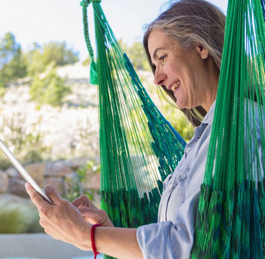 An elderly woman holds a tablet in her hand