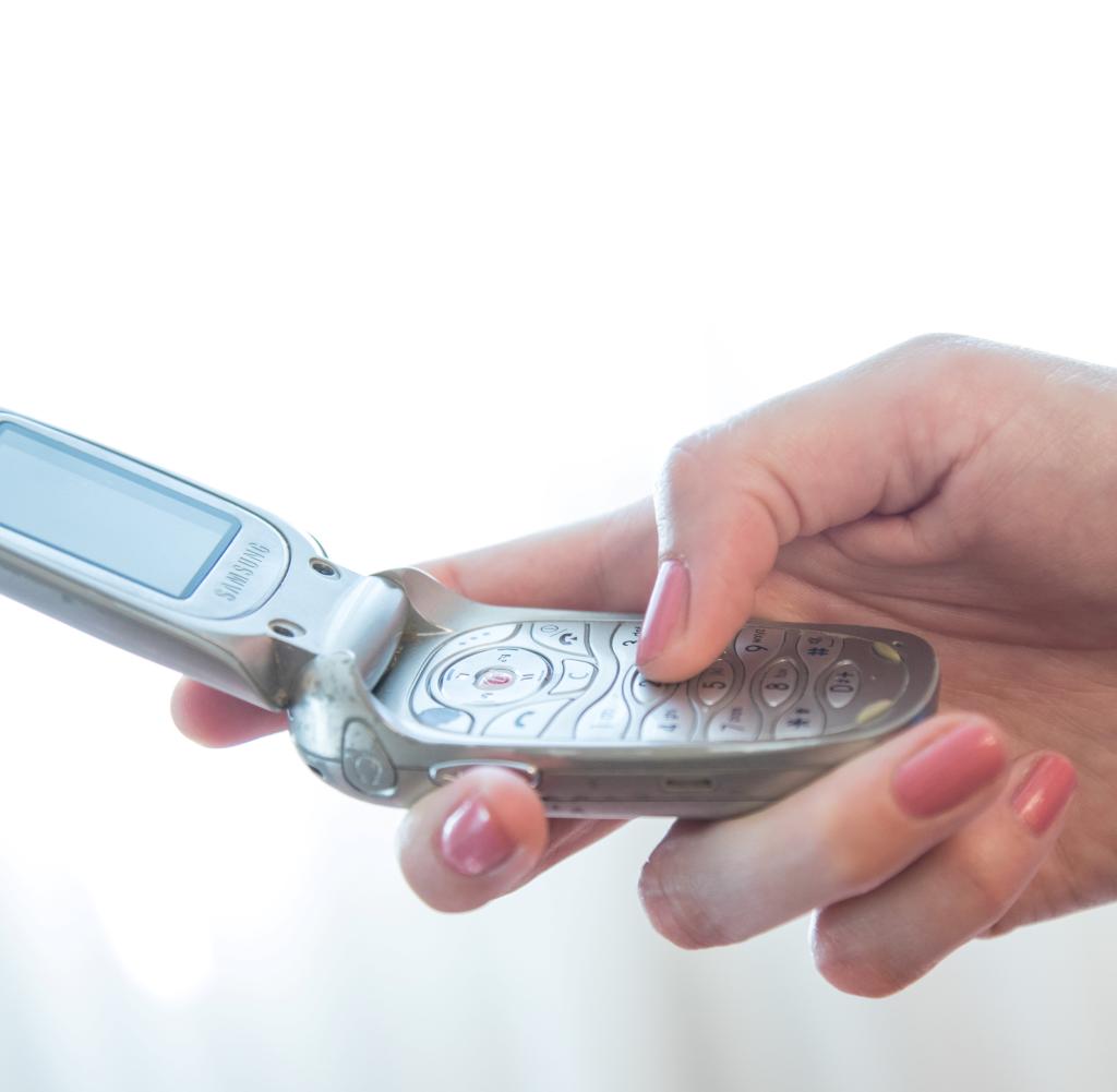 A clamshell phone in hand.