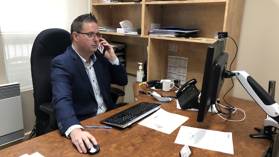 Guy Thibault on the cell phone in his office.